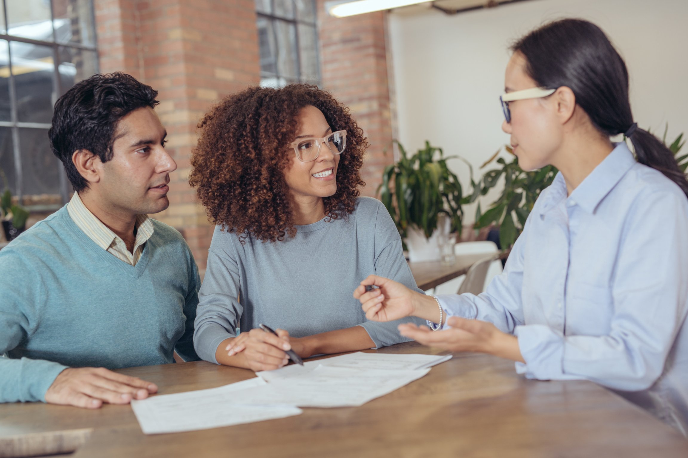 Couple with Paperwork Talking to a Financial Advisor 